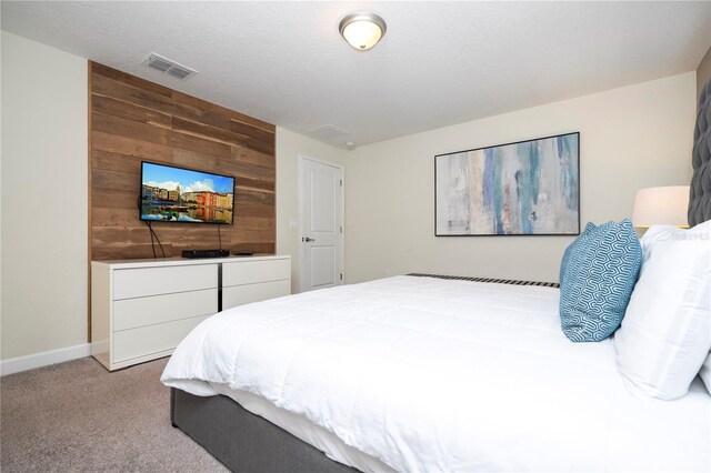 bedroom featuring light carpet and wooden walls