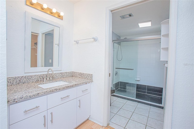 bathroom with vanity, tile patterned floors, and a shower with shower door