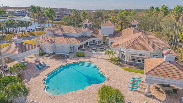 view of pool with a water view and a patio area