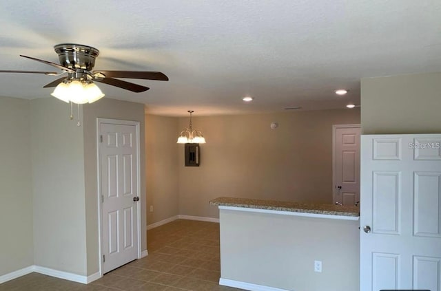 spare room featuring ceiling fan with notable chandelier and light tile patterned floors