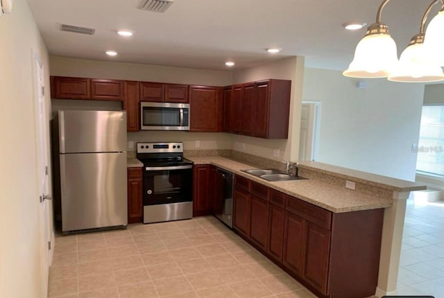 kitchen featuring kitchen peninsula, hanging light fixtures, stainless steel appliances, and sink