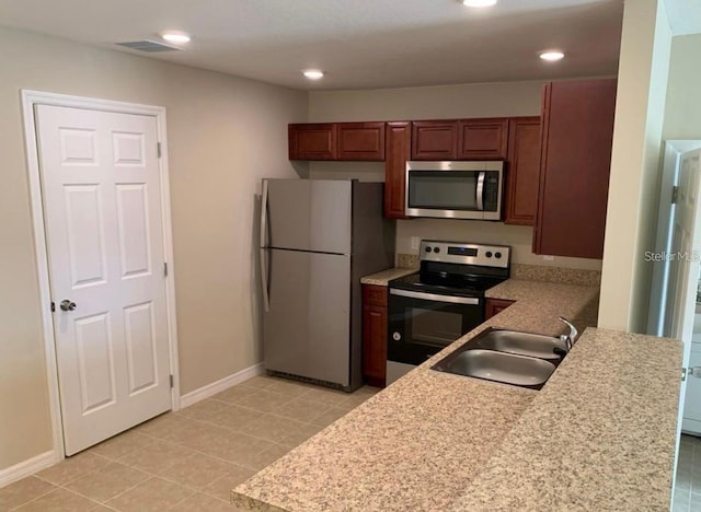 kitchen featuring kitchen peninsula, stainless steel appliances, sink, and light tile patterned flooring