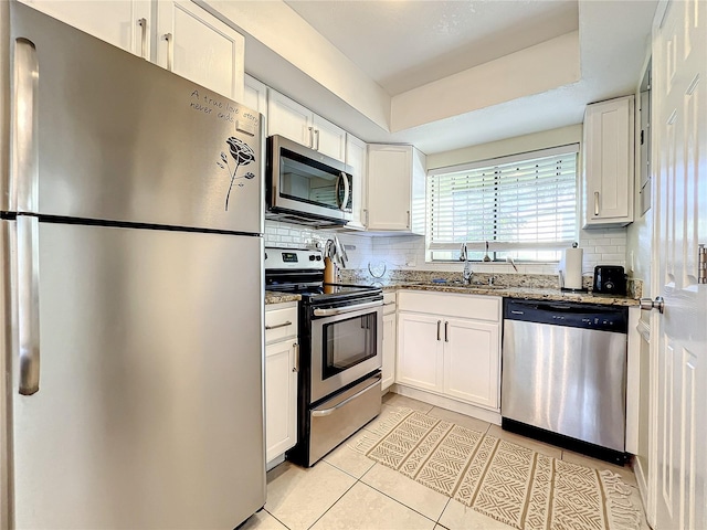 kitchen with stone counters, sink, white cabinets, and stainless steel appliances