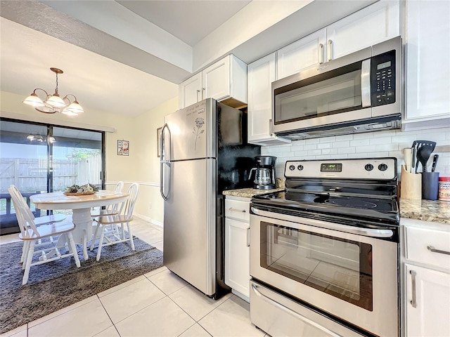 kitchen with stainless steel appliances, light tile patterned flooring, a chandelier, white cabinetry, and tasteful backsplash