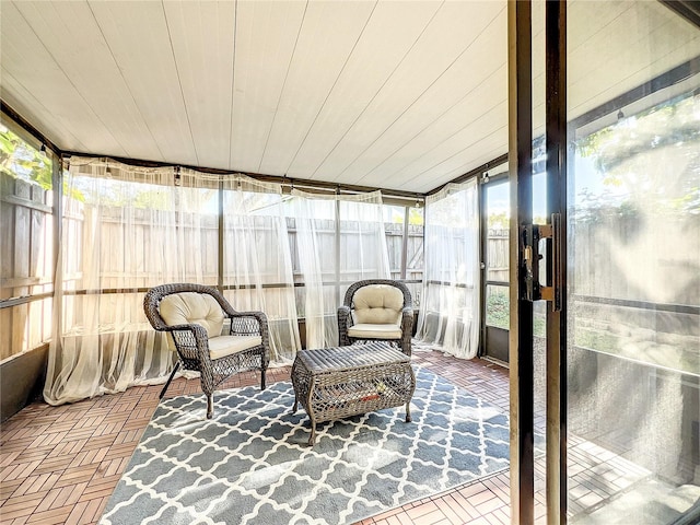 sunroom featuring wood ceiling and a wealth of natural light