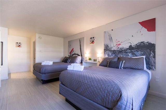 bedroom featuring baseboards and wood finished floors