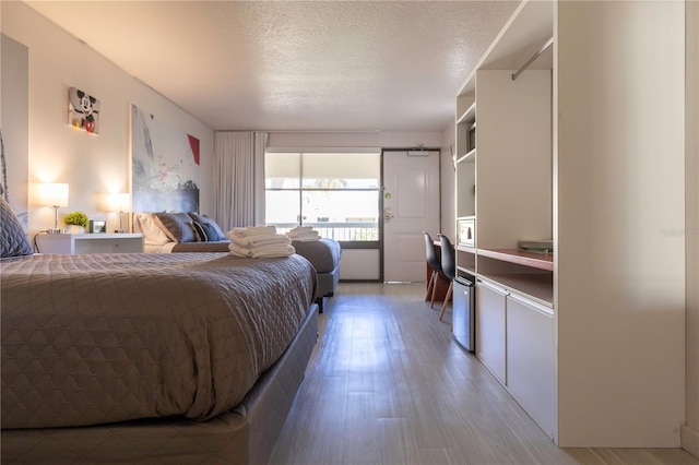 bedroom featuring a textured ceiling and wood-type flooring