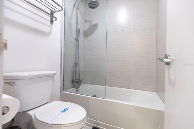 bathroom with toilet and tiled shower / bath