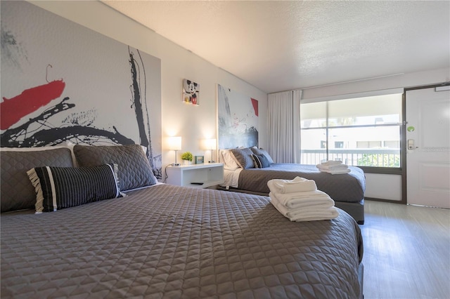 bedroom with wood-type flooring and a textured ceiling