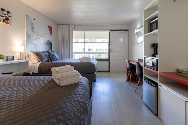 bedroom with a textured ceiling and wood-type flooring