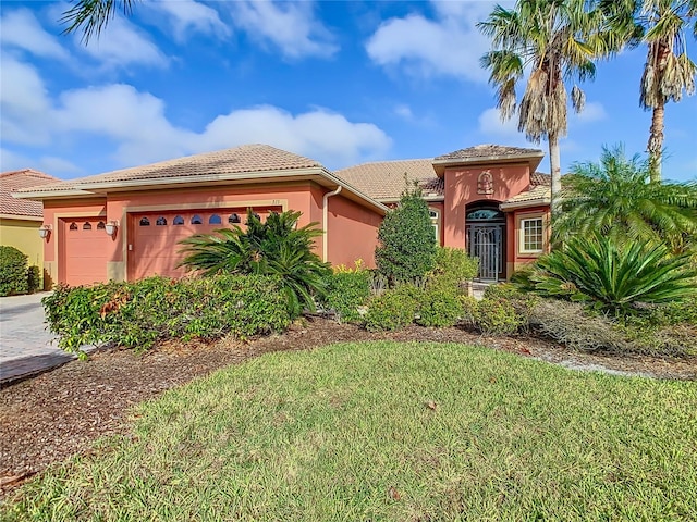 mediterranean / spanish-style house with a front yard and a garage