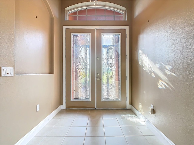 doorway with light tile patterned floors and french doors