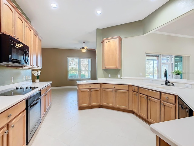 kitchen with black appliances, kitchen peninsula, sink, and a wealth of natural light