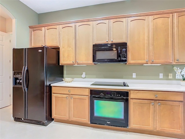 kitchen featuring light brown cabinetry and black appliances