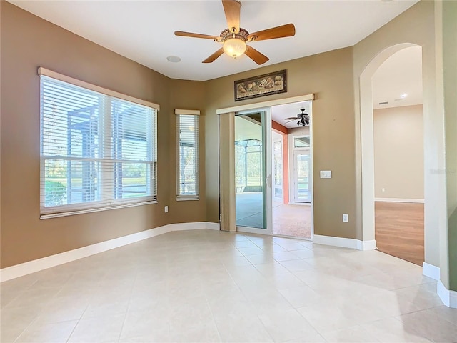 tiled spare room featuring ceiling fan