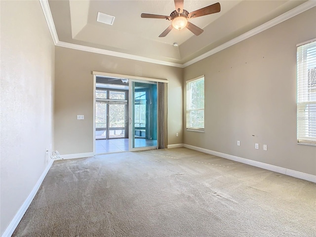 unfurnished room featuring ceiling fan, a raised ceiling, light colored carpet, and crown molding