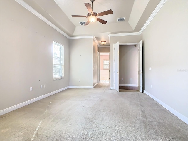 unfurnished bedroom with ceiling fan, a raised ceiling, light colored carpet, and crown molding