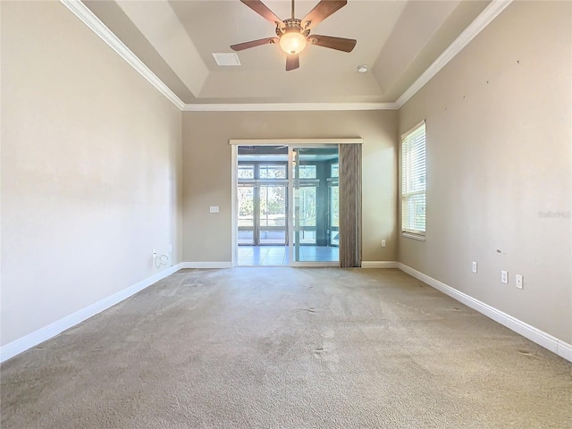 carpeted empty room with ceiling fan, a raised ceiling, and crown molding