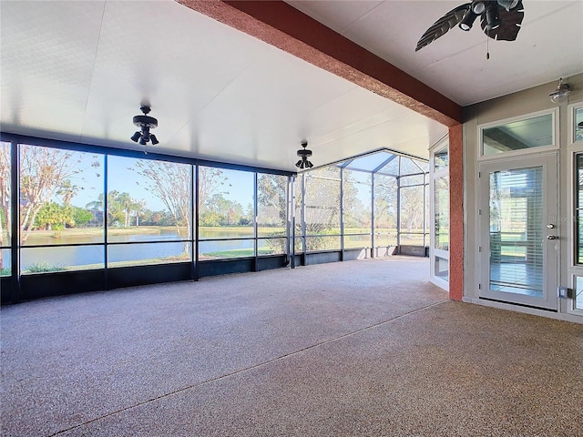 unfurnished sunroom featuring beam ceiling, ceiling fan, and a water view