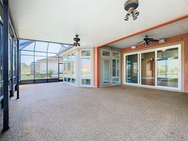 unfurnished sunroom featuring ceiling fan