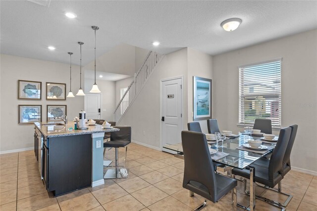 tiled dining space with a textured ceiling and sink