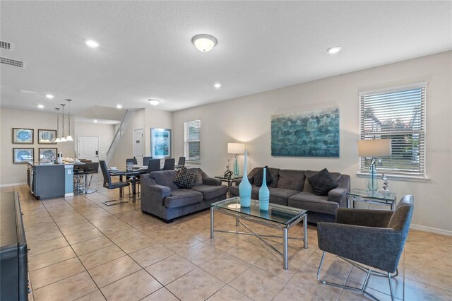 tiled living room featuring a textured ceiling