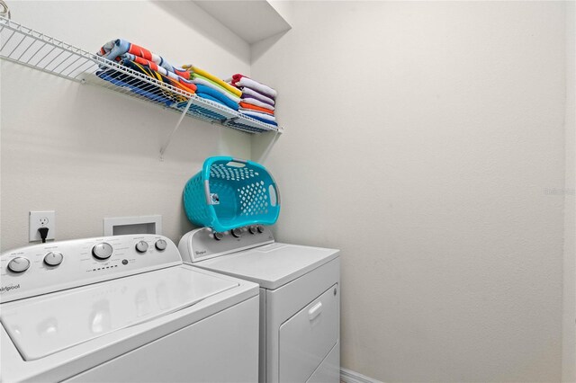 clothes washing area featuring separate washer and dryer