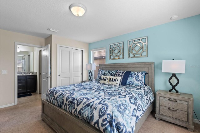 bedroom featuring a closet, light colored carpet, and connected bathroom