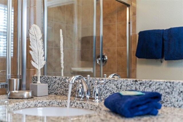 bathroom featuring a shower with door and vanity