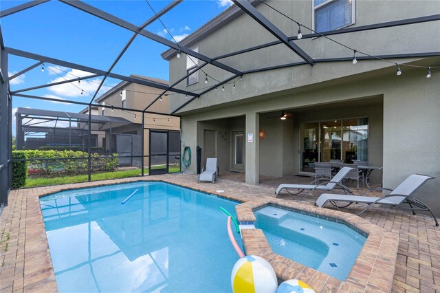 view of pool with an in ground hot tub, a patio, and a lanai