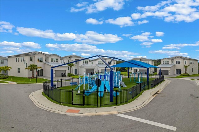 view of front facade with a playground, a garage, and a front lawn