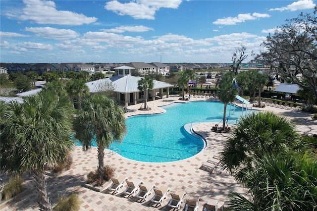 view of swimming pool featuring a water slide and a patio