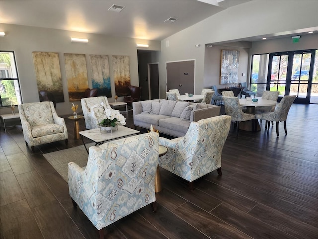 living room with dark wood-type flooring, lofted ceiling, and french doors