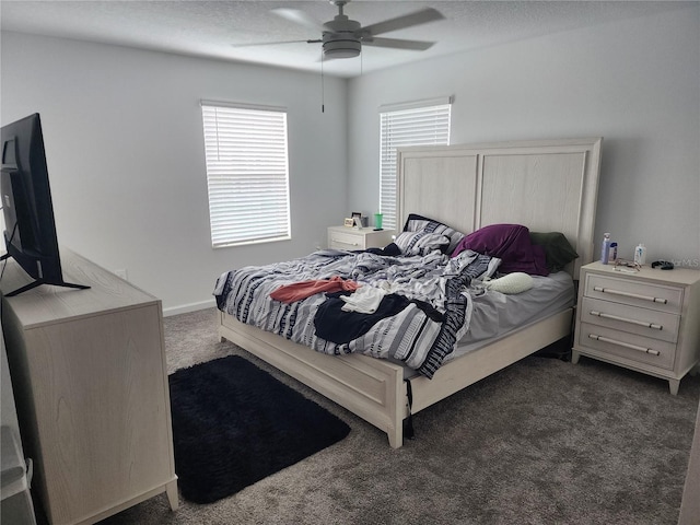 bedroom with a textured ceiling, dark colored carpet, and ceiling fan