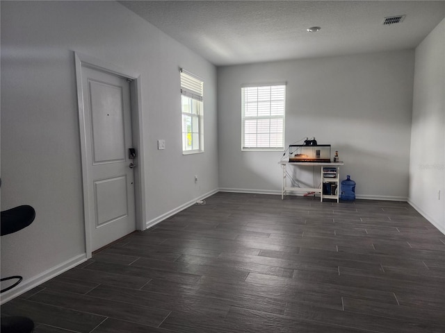 entrance foyer with dark wood-type flooring and a textured ceiling