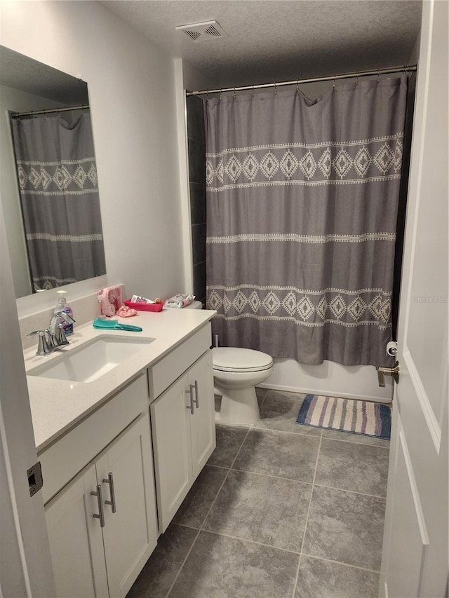 full bathroom with tile patterned flooring, a textured ceiling, shower / tub combo with curtain, vanity, and toilet