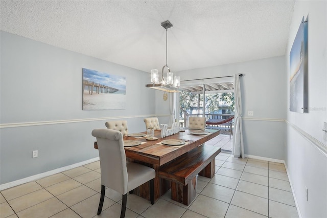 tiled dining room featuring a chandelier and a textured ceiling