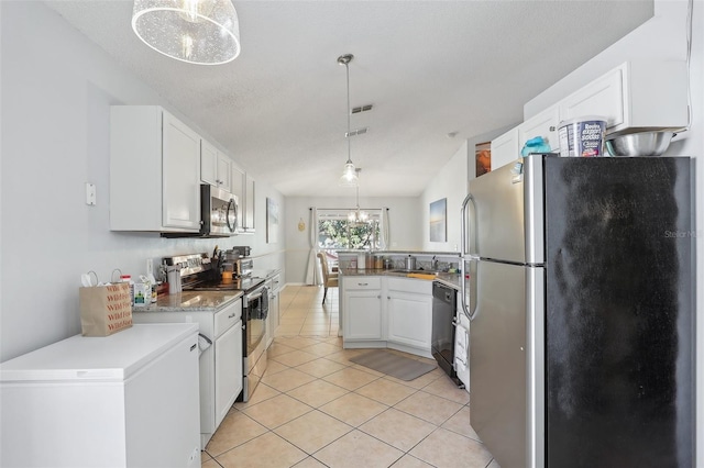 kitchen featuring sink, hanging light fixtures, a textured ceiling, white cabinets, and appliances with stainless steel finishes