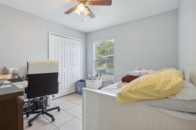 bedroom with ceiling fan, light tile patterned floors, and a closet