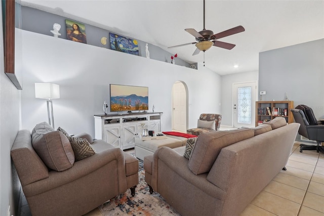 tiled living room with ceiling fan and high vaulted ceiling