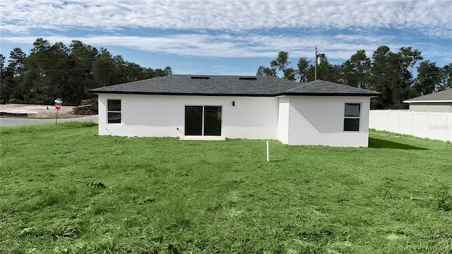 rear view of property with a lawn