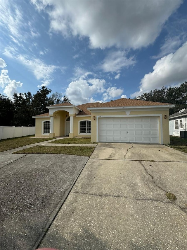 single story home featuring a garage and a front lawn