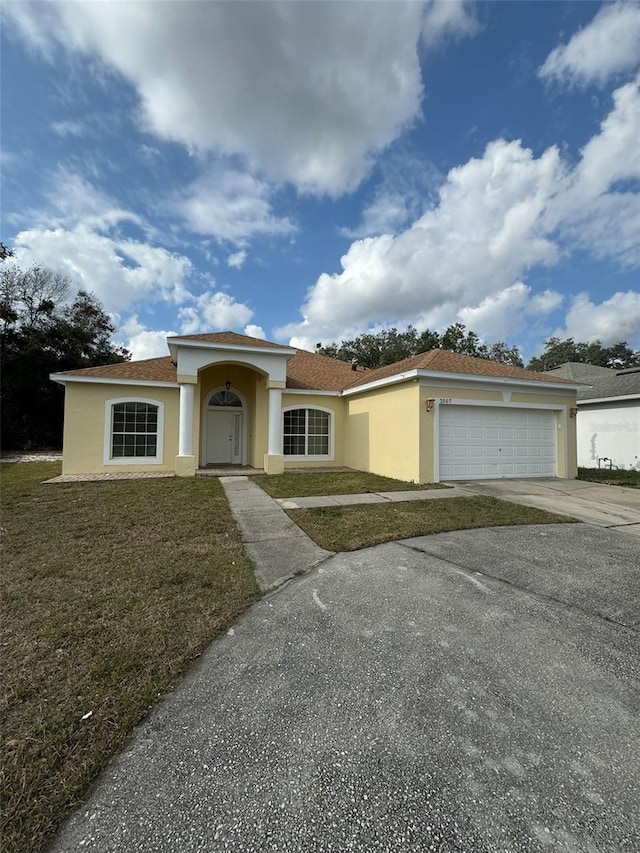 view of front of house with a garage and a front yard