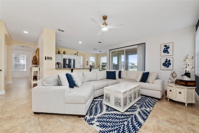 living room with ceiling fan, light tile patterned floors, and a wealth of natural light