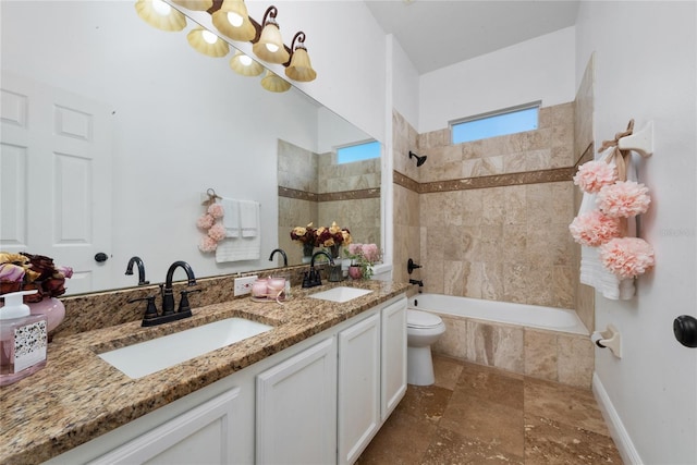 full bathroom with vanity, tiled shower / bath combo, and toilet