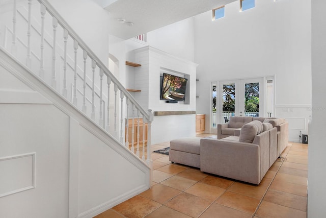 tiled living room with french doors and a towering ceiling