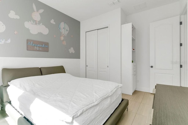 bedroom with a closet and light tile patterned flooring