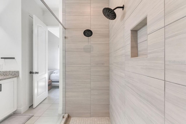 bathroom with vanity, a tile shower, and tile patterned floors