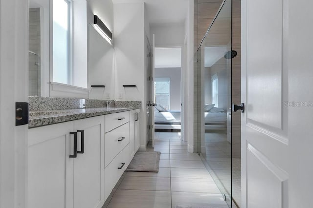 bathroom featuring vanity, tile patterned floors, and walk in shower