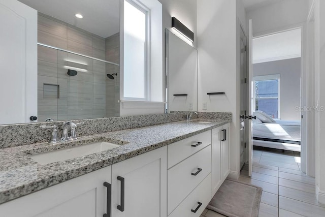 bathroom with a shower with door, vanity, and tile patterned flooring